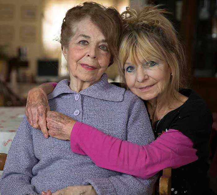 Family caregiver with her aging mother at home, reflecting the support needed to refer a loved one to Meals on Wheels