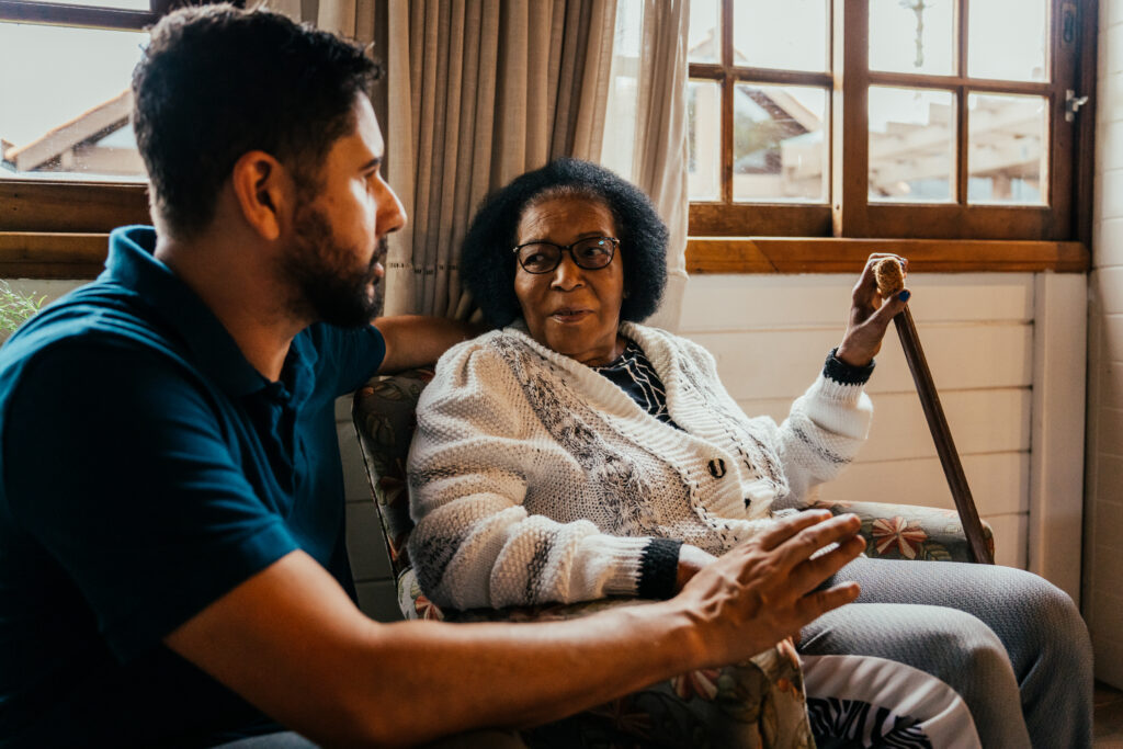 Volunteer talking to elderly woman in her home
