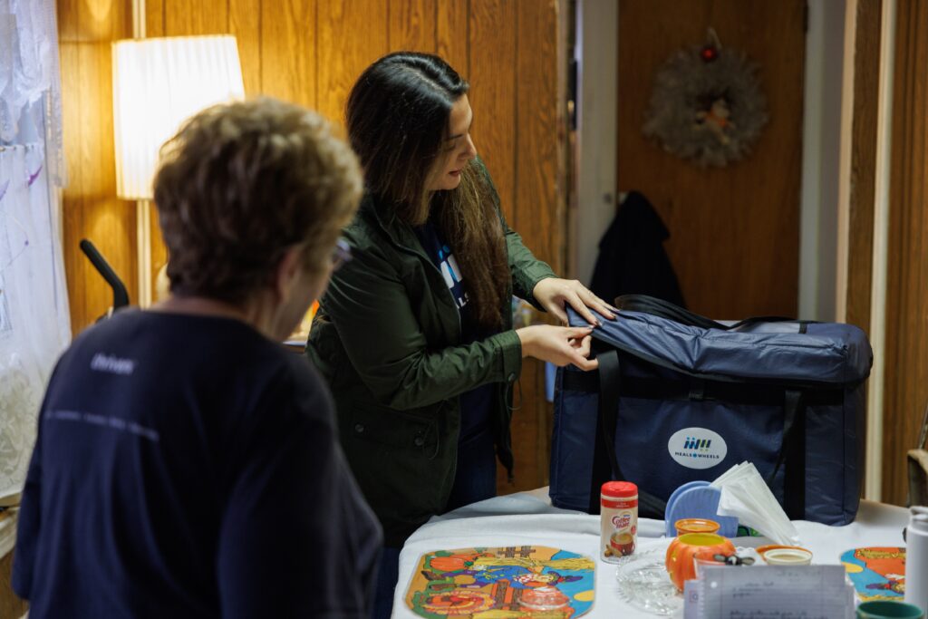 Meals on Wheels volunteer delivering food to a homebound older adult in Weld County, showing in-home meal support, daily check-ins, and help for aging in place