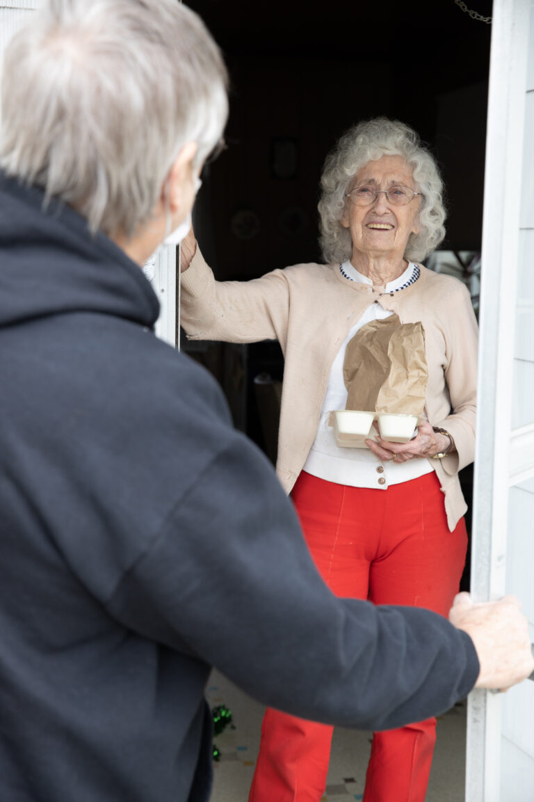 Meals on Wheels volunteer visiting an older adult at home with a nutritious meal in Weld County