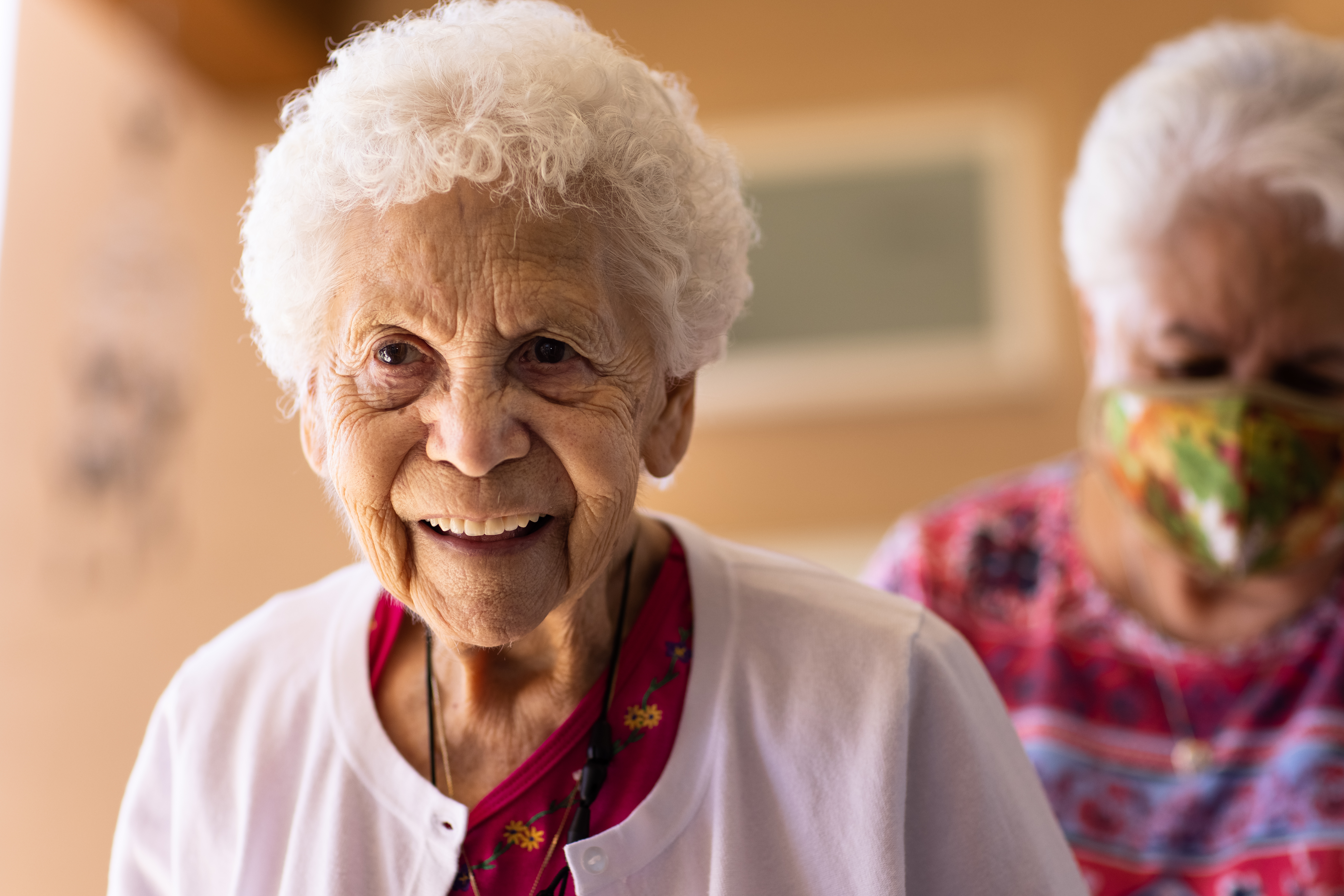 Smiling older woman during a friendly Meals on Wheels visit supporting healthy aging at home.
