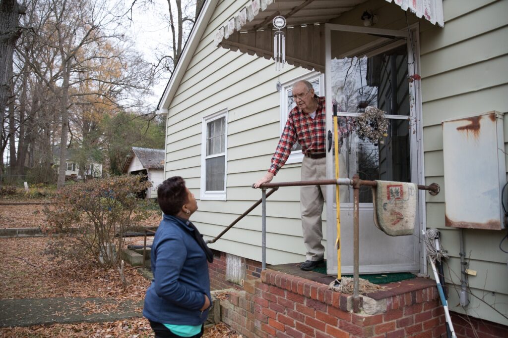 Meals on Wheels volunteer checking in with an older adult at home, supporting senior nutrition, safety, connection, and independent aging.